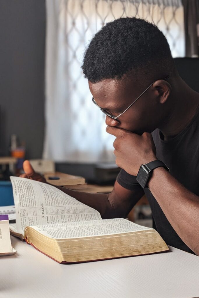 pexels-photo-3118214-3118214 Young man deeply engaged in reading a book at home, fostering knowledge and wisdom.